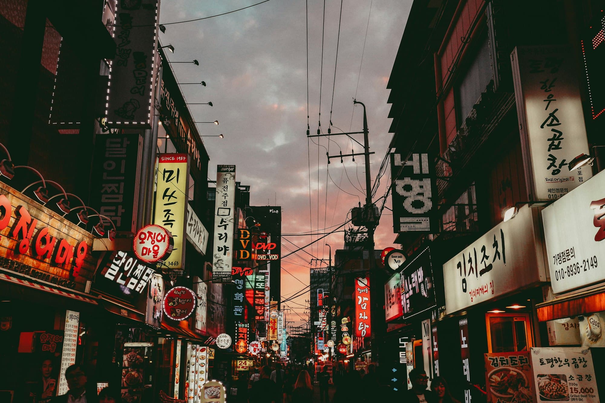 A busy shopping street in Seoul at dusk